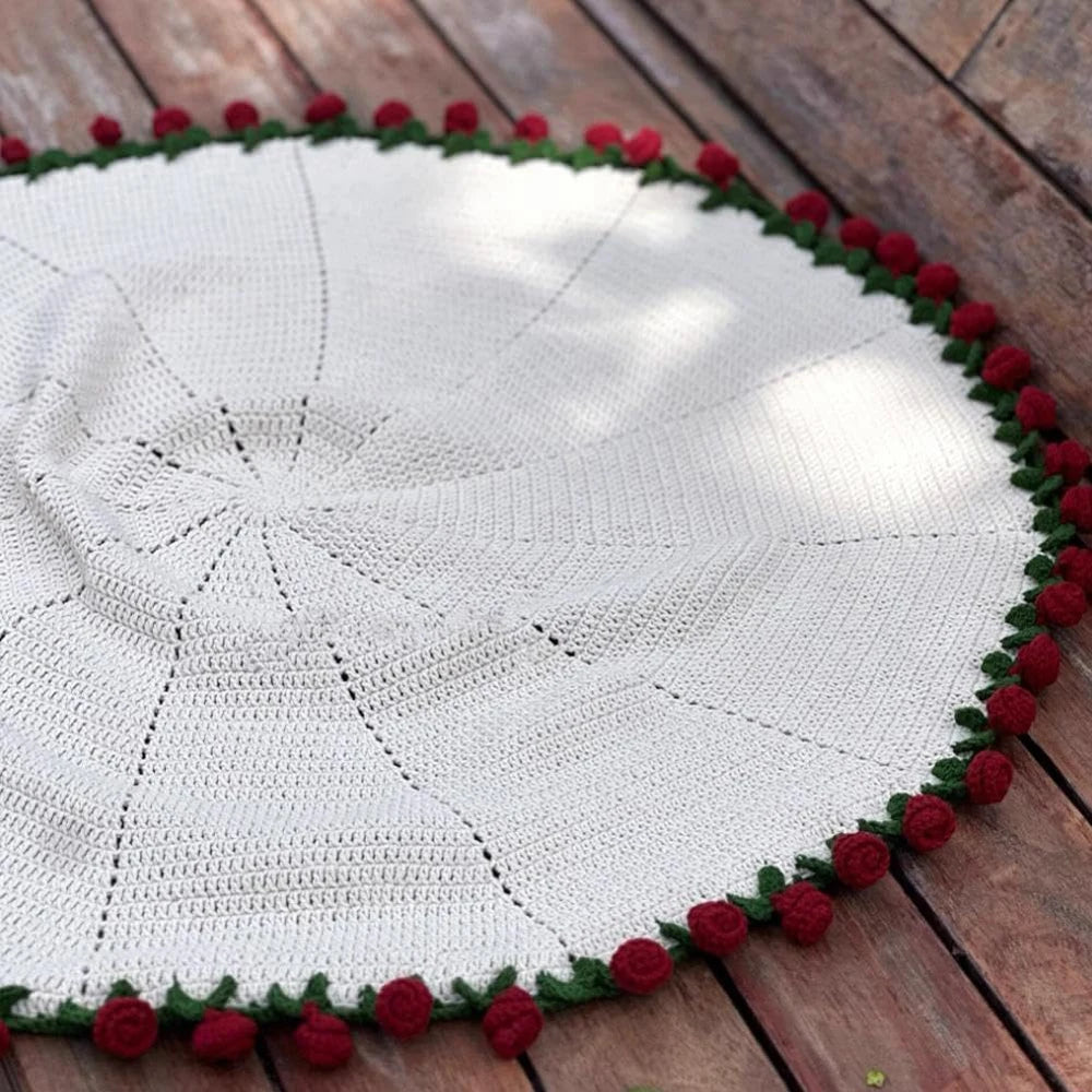 Round knit blanket with red rose border laid flat